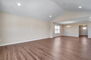 Spacious empty living room with wood flooring, recessed lighting, and beige walls, perfect for setting up a sleek Carter dispatch station.
