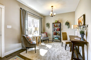 Cozy room in Westwood with chairs, a rug, bookshelves, and a window. Natural light brightens the modern decor, making it feel like a peaceful dispatch station for your thoughts and ideas.