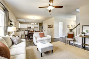 Spacious open-plan living room and kitchen with light furniture, a ceiling fan, and decorative accents, reminiscent of Westwood's charming style.