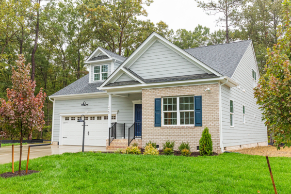 Nestled in the heart of Poplar Village, this modern suburban house boasts a brick and siding exterior, complete with a charming front porch, garage, and landscaped yard under the cloudy skies of Shenandoah.