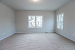 Empty room with beige carpet, gray walls, and two windows—perfect for new homes in Richmond VA.