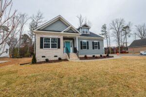 Gray and white house with a turquoise door and front steps—discover new homes in Richmond VA on a cloudy day.