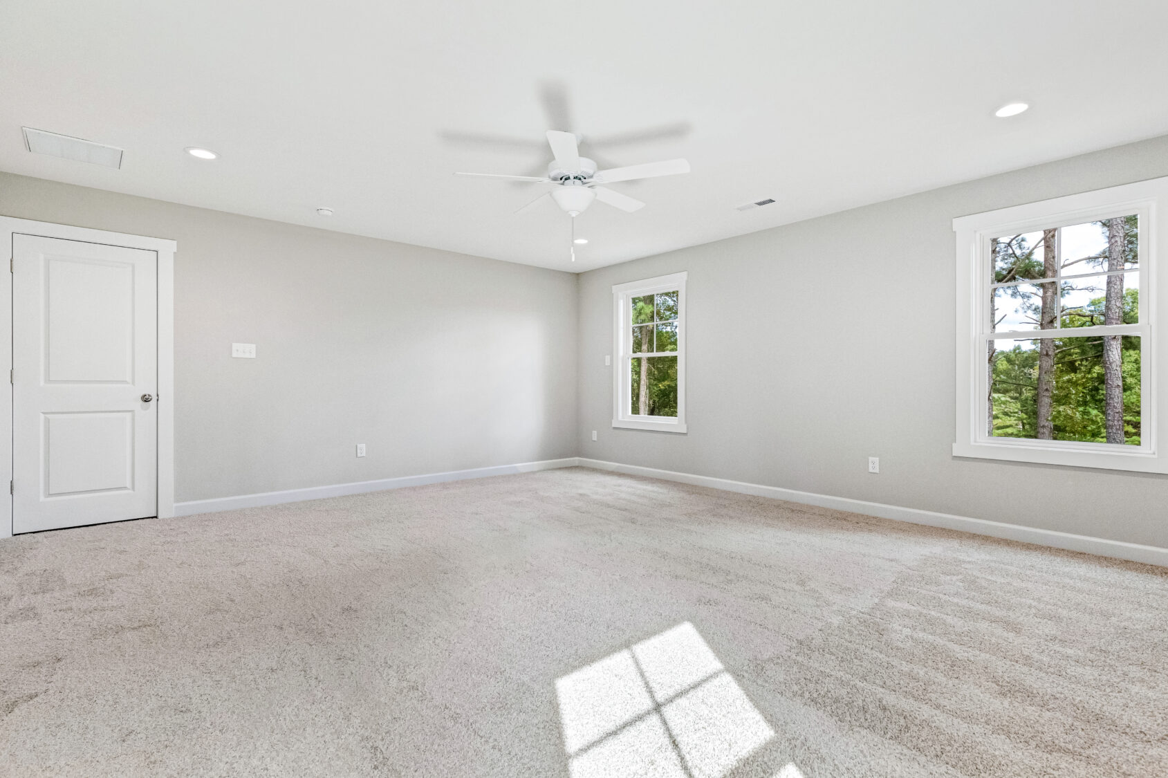 A room with a fan and windows