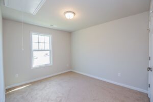 Empty room with beige carpet, white walls, bright window—perfect for new homes in Richmond VA.