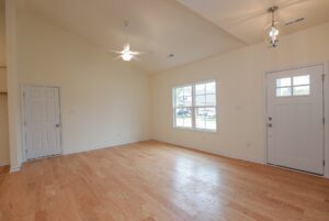 Bright empty room with wooden floors—perfect for new homes in Richmond VA, featuring a window and glass-panel door.