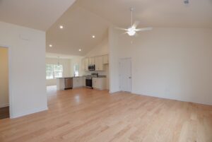 Open plan living area in one of the stunning new homes in Richmond VA, featuring light wood floors and a modern kitchen.