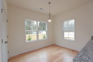 Bright, empty room with wood floors and cream walls—perfect for new homes in Richmond VA.