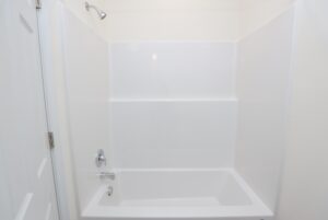 White bathtub and shower combo with built-in shelves, perfect for new homes in Richmond VA.