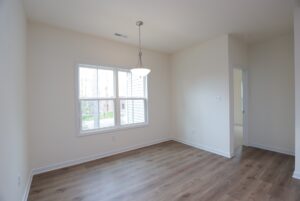 Bright empty room with wood floors, white walls, and window—ideal for new homes in Richmond VA.