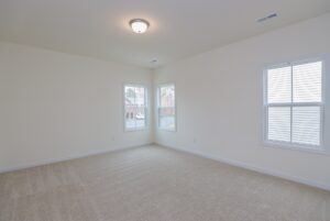 Bright empty room with beige carpet and cream walls, perfect for new homes in Richmond VA seeking ample natural light.