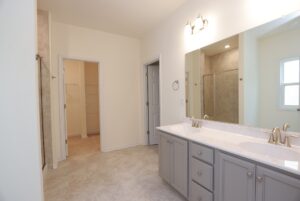 Modern bathroom with double sink vanity, large mirror—features found in new homes in Richmond VA.