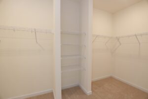 Spacious walk-in closet with white wire shelves and beige carpet, perfect for new homes in Richmond VA.