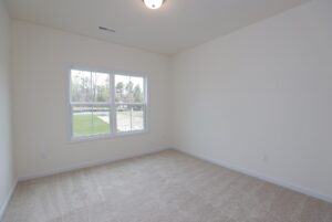Empty room with beige carpet, cream walls, and large window—perfect for new homes in Richmond VA.
