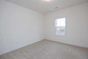 Empty room with beige carpet and white walls, offering natural light—ideal for new homes in Richmond VA.