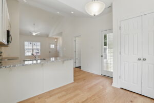 Bright, modern kitchen at The Charles features granite counters, wood floors, and double doors to a patio.