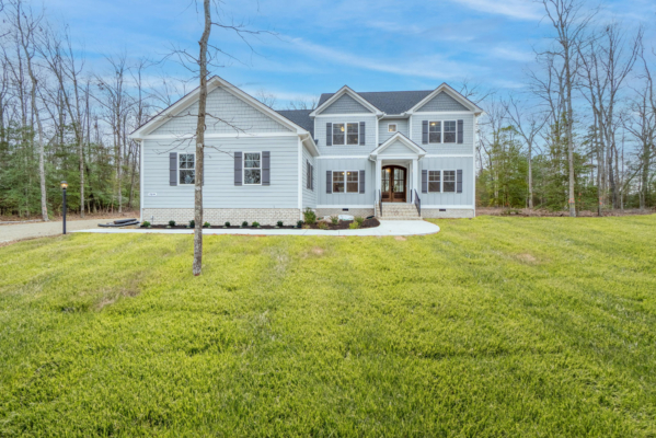 Two-story white house with gray roof, front porch, and large yard—ideal for those seeking new homes in Virginia.