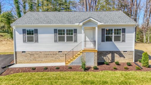 Single-story house with gray siding, brick foundation, and landscaped yard—ideal for new homes in Richmond VA.