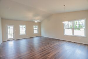 Spacious empty room with wood flooring and large windows, perfect for new homes in Richmond VA.