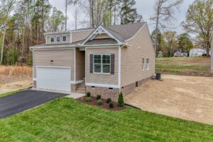 Single-story beige house with two-car garage—perfect for those seeking new homes in Richmond VA on a cloudy day.