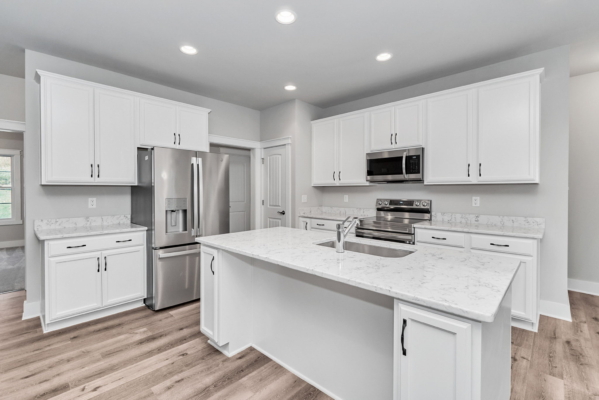 Modern kitchen with white cabinets, marble countertops, stainless steel appliances, and a central island.