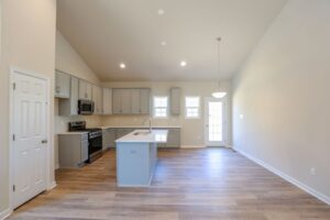 Spacious kitchen with light gray cabinets, an island, stainless steel appliances, and hardwood floors.