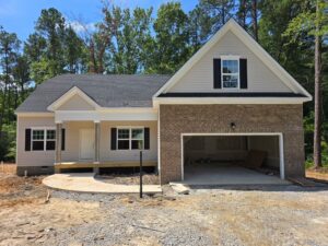Newly built single-story house on Lot 57 in Patrick Henry Heights with brick, siding, front porch, and two-car garage.