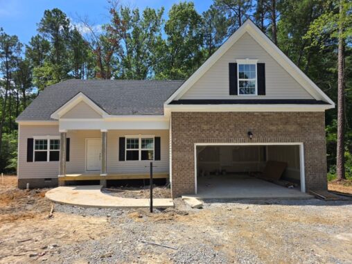 Newly built single-story house on Lot 57 in Patrick Henry Heights with brick, siding, front porch, and two-car garage.