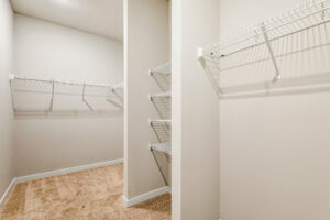 Empty walk-in closet with beige carpet, white walls, and white wire shelving in Patrick Henry Heights Lot 57.
