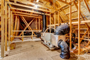HVAC unit with black insulated ductwork installed in a wooden attic at Patrick Henry Heights, Lot 57.