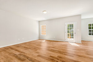 Bright, empty room in Lot 57, Patrick Henry Heights with light wood flooring and large windows for natural light.