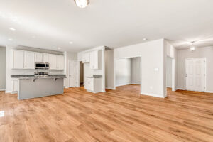 Spacious modern kitchen and living area in Patrick Henry Heights, Lot 57, with wood floors and natural light.