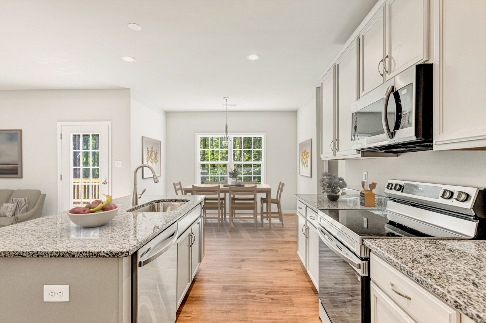 Modern kitchen in Patrick Henry Heights with stainless appliances, granite counters, and bright dining area. Lot 57.
