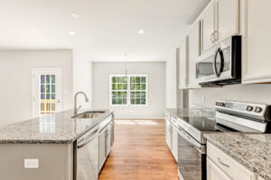 Modern kitchen in Patrick Henry Heights with granite countertops, stainless steel appliances, and large windows.