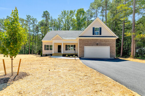 Single-story home in Patrick Henry Heights, Lot 57, with garage, porch, driveway, and a newly landscaped yard.