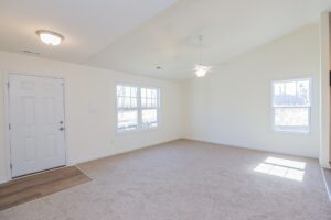 Empty room with beige carpet, white walls, windows, ceiling fan—perfect for new homes in Richmond VA.