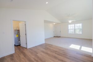Bright room with wood flooring, ceiling fan, and large windows—perfect for new homes in Richmond VA.