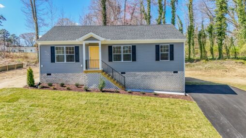 Single-story gray house with yellow door and black shutters—perfect for those seeking new homes in Richmond VA.