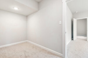 Empty, carpeted room in Poplar Village with light-colored walls and an open doorway to Lot 22.
