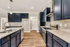 Modern kitchen with dark cabinets, stainless steel appliances, granite countertops, and wood flooring.