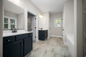 Spacious modern bathroom at Shirley Commons with double sinks, black cabinets, large mirrors, and natural light.