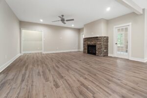 Spacious living room with wood flooring, fireplace, and glass door—ideal for new homes in Richmond VA.
