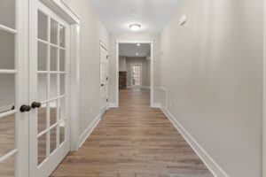 Bright hallway with wooden floors and French doors, a stylish feature in new homes in Richmond VA.