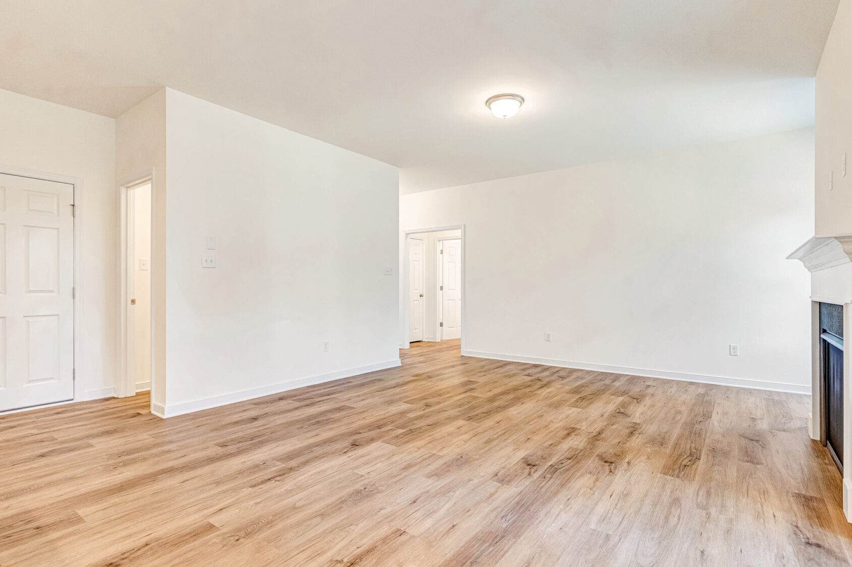 A room with a wood floor and white walls in Poplar Village Lot 29.