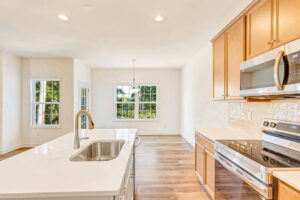 Bright modern kitchen in Poplar Village with wood cabinets, white countertops, and large windows letting in natural light.