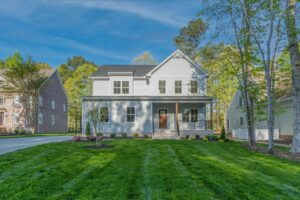 Charming white two-story house in Shirley Commons, offering senior living in Stafford with a sunny porch and neat lawn.