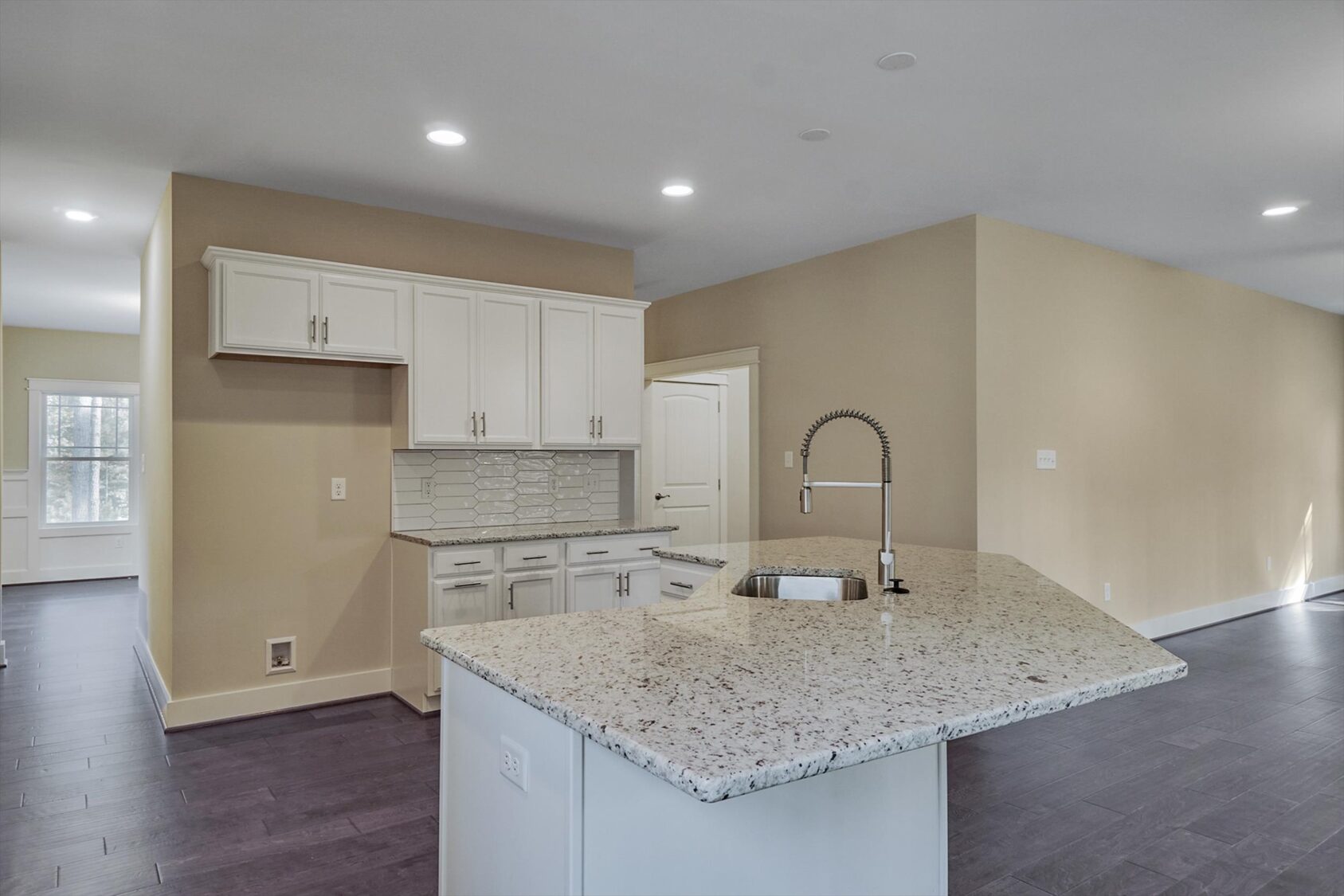 Modern kitchen in Albany with white cabinets, granite countertops, and a gooseneck faucet in Poplar Village.