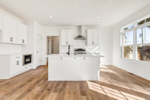 Bright modern kitchen in Poplar Village featuring white cabinets, stainless appliances, and wood-style flooring.
