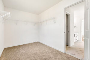 Spacious walk-in closet with carpet, white walls, and wire shelving in Lot 13, Poplar Village; connected to bathroom.