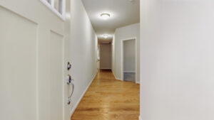 A hallway with wooden floors, white walls, and ceiling lights in a serene Somerset Hill or Bethany home.