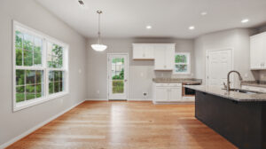 Bright, modern Bethany kitchen with wood floors, white cabinets, granite counters, and large Somerset Hill windows.